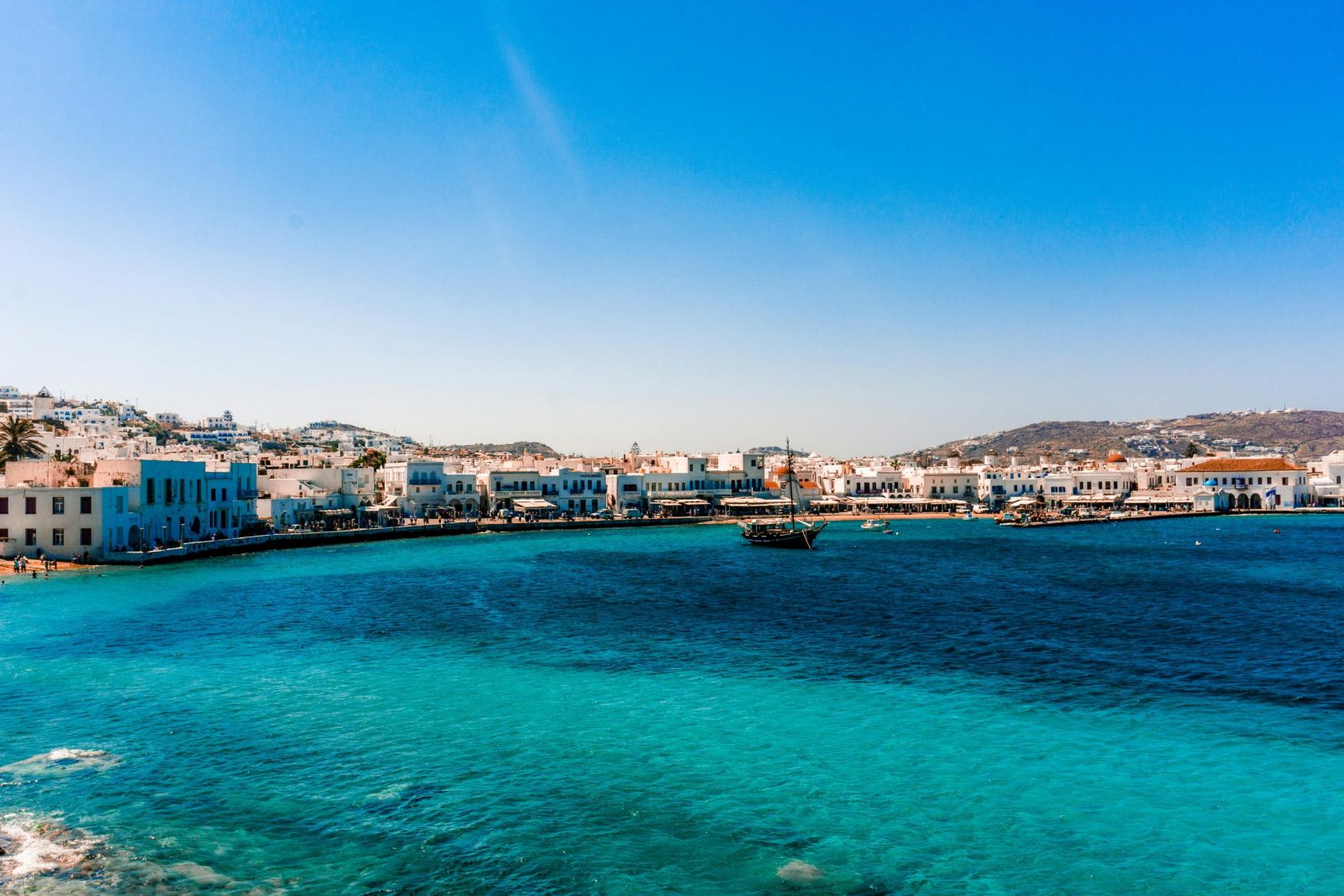 Een adembenemend uitzicht op de haven van Mykonos met helderblauw water onder een stralende zomerhemel.